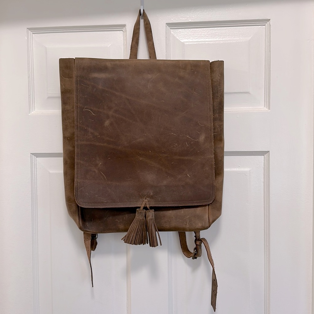 Boutonnè real leather backpack with tassels and adjustable straps.